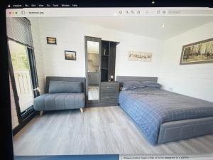 1 dormitorio con 1 cama y 1 silla en Lakeside Lodges, en Leicester