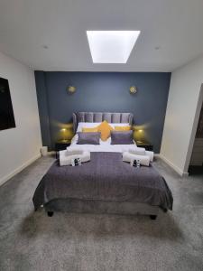 a bedroom with a large bed with a blue wall at Stunning 1 Bed Apt Minutes From Bham City Centre! in Birmingham