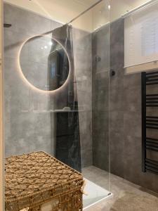 ein Bad mit einer Glasdusche und einem Spiegel in der Unterkunft Jolie maison familiale in Valbonne