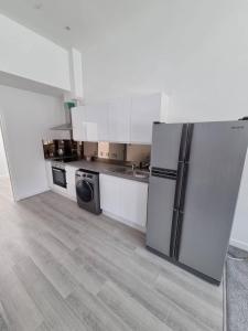 eine Küche mit einem Kühlschrank und einem Geschirrspüler in der Unterkunft Stunning 1 Bed Apt Minutes From Bham City Centre! in Birmingham