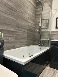 uma banheira na casa de banho com um chuveiro em Ensuite Room with Private Bathroom at Walsall em Walsall