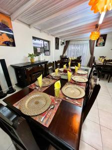 uma sala de jantar com uma longa mesa de madeira com cadeiras em Keeme-Nao Self Catering Apartments em Gaborone