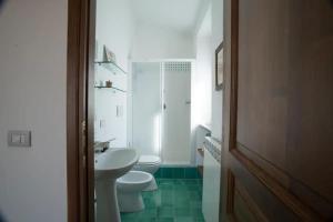 Baño blanco con aseo y lavamanos en Le Terrazze della Tuscia, en Latera