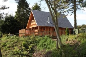 une grande cabane en bois avec un toit en gambrel dans l'établissement Horsey Reach Lodge, à Stanley