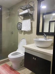 uma casa de banho com um WC, um lavatório e um espelho. em Suite Torre Bellini em Guayaquil
