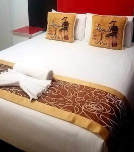Cama blanca con 2 almohadas y manta en Keeme-Nao Self Catering Apartments, en Gaborone