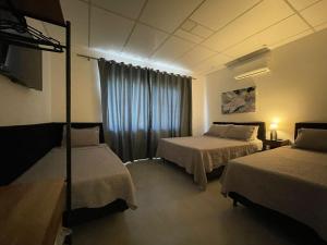 um quarto de hotel com duas camas e uma janela em VILLA BILAC 08 - Aconchegante Studio próximo à Vila Germânica em Blumenau