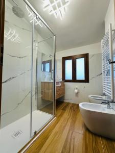 bagno con doccia in vetro e lavandino di Accogliente Villa immersa nel verde a Lido dei Pini