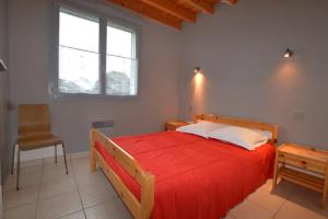 a bedroom with a red bed and a chair at Roche Blanche 1 in Saint-Lunaire