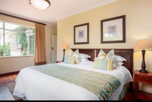 a bedroom with a large white bed with pillows at The Top Manor in Durban