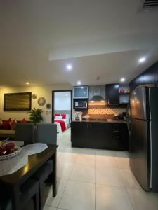 a kitchen and living room with a table and a refrigerator at Puerto santa Ana Torres Bellini in Guayaquil