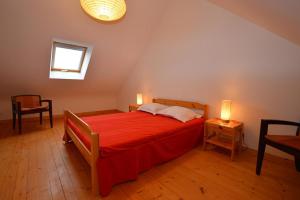 een slaapkamer met een rood bed en 2 lampen bij Roche Blanche 1 in Saint-Lunaire
