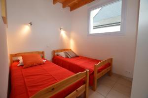 two beds in a room with a window at Roche Blanche 1 in Saint-Lunaire