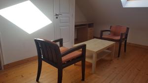 een eetkamer met 2 stoelen en een tafel en stoelen bij Roche Blanche 1 in Saint-Lunaire