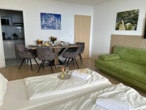 a living room with a green couch and a table at Ferienwohnung Uns Uwe in Freyung