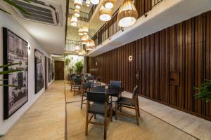 a dining room with tables and chairs and wooden walls at Casa Continental Hotel Boutique & Suites - Adults Only in Mérida