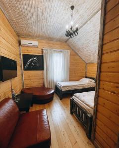 una camera con due letti e un divano in una cabina di DachaLove a Pogreby