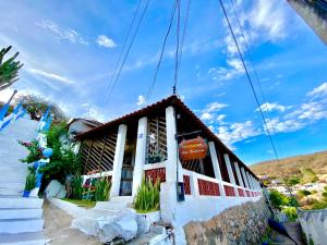 a small white building with a sign on it at Pousada Asa Branca in Piranhas