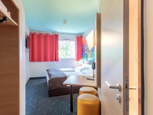 a small room with a table and a red curtain at B&B Hotel Passau in Passau