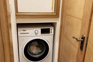 a washer and dryer in a small room at Stylish and Cosy 3 Bedroom Appartment in London