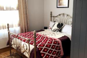 a bedroom with a metal bed with a red and white comforter at Stylish and Cosy 3 Bedroom Appartment in London