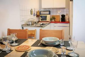 a kitchen with a table with plates and glasses on it at Schluchseezauber 1123 - Alm Chic mit Pool & Sauna in Schluchsee +11 photos