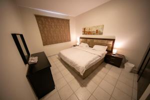 a small bedroom with a bed and a window at Blue Star Villa in Durat Alarous