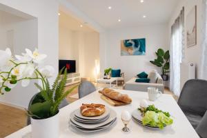a white living room with a table with food on it at Rosenberg-Oase - Zentral, Stellplatz, 78m2, große Terasse, Business & Privat in Heilbronn