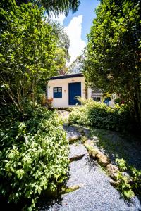 una casa con una puerta azul en medio de un jardín en Pousada Ronco do Bugio, en Piedade
