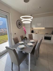 a dining room with a table and chairs and a kitchen at Yachting Residence in Lavena Ponte Tresa
