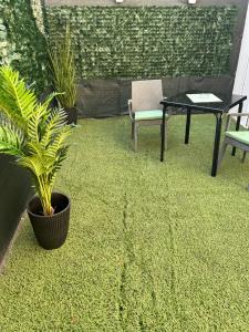 een patio met een plant en een tafel en stoelen bij Anesis Airport rooms 204 in Koropíon