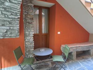 uma mesa e cadeiras sentadas ao lado de uma parede em Al San Michele em Stresa