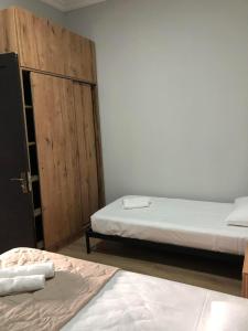 una camera con due letti e una porta in legno di Chaki 2 a Ureki