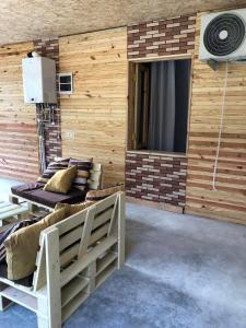 una camera con una parete in legno, un divano e sedie. di Chaki 2 a Ureki