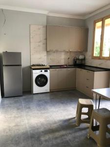 una cucina con lavatrice e un apparecchio bianco di Chaki 2 a Ureki