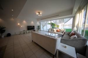 Una gran sala de estar con un sofá y un televisor. en Blue Star Villa, en Durat Alarous