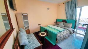 1 dormitorio con cama verde y balcón en SIDI ALI BOUSSERGHINE en Sefrou