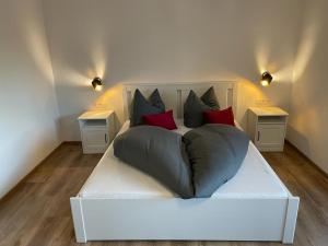 een wit bed met kussens in een kamer bij Haus Ribeiro in Schluchsee