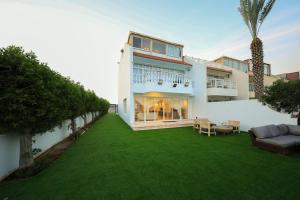 una gran casa blanca con un patio verde en Blue Star Villa, en Durat Alarous