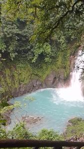 uma piscina de água junto a uma cascata em Habitacion en Bijagua em Bijagua