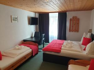 a hotel room with two beds and a desk at Weisses Rössel-Cavallo Bianco in Werfen