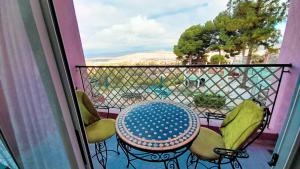 una mesa y sillas en un balcón con vistas en SIDI ALI BOUSSERGHINE en Sefrou