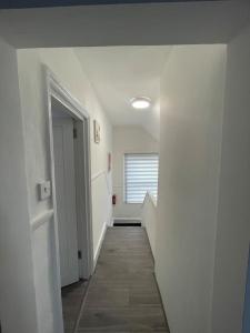 a hallway with a hallway leading to a room with a hallway at Opal - Executive London Flat in South Norwood