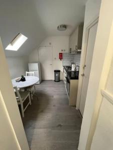 a hallway of a kitchen with a table and refrigerator at Opal - Executive London Flat in South Norwood