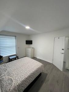 biała sypialnia z łóżkiem i oknem w obiekcie Opal - Executive London Flat w mieście South Norwood
