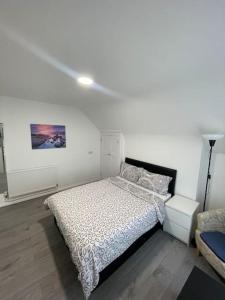 a bedroom with a bed and a white wall at Opal - Executive London Flat in South Norwood
