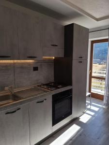 a kitchen with a stove and a sink and a window at Centro Mezzano Romantica, affitto camere in Mezzano