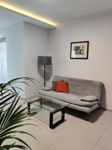 uma sala de estar com um sofá e uma mesa de vidro em DePiro Point Deluxe - Sliema Holiday Rental em Sliema