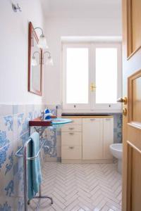 a bathroom with a sink and a toilet and a window at Capri Lovers in Capri