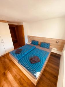 1 dormitorio con 1 cama grande con sábanas azules y almohadas azules en Appartement am Moosbach, Fieberbrunn - St. Jakob, en Sankt Jakob in Haus